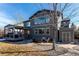 Expansive backyard featuring a covered deck, stone patio with seating, shed, and lush lawn at 11043 Valleybrook Cir, Highlands Ranch, CO 80130