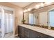 Bright bathroom features a double vanity with marble countertop and a large mirror with modern lighting at 11043 Valleybrook Cir, Highlands Ranch, CO 80130