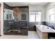 Modern bathroom with a glass-enclosed shower featuring unique tilework and a soaking tub next to a bright window at 11043 Valleybrook Cir, Highlands Ranch, CO 80130