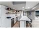 Basement kitchenette with white cabinets, open shelving, stainless steel appliances, and bar seating at 11043 Valleybrook Cir, Highlands Ranch, CO 80130