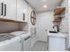 Functional laundry room with modern washer and dryer, ample storage cabinets, and stylish patterned flooring at 11043 Valleybrook Cir, Highlands Ranch, CO 80130