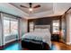 Comfortable main bedroom with tray ceiling, ceiling fan, wood accent wall and natural light at 11043 Valleybrook Cir, Highlands Ranch, CO 80130