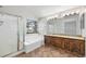 Bright bathroom featuring a double vanity, soaking tub with window, and glass enclosed shower at 2238 S Nile Ct, Aurora, CO 80014