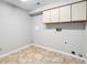 Utility room features tile flooring, overhead cabinet, and laundry hookups for convenience at 2238 S Nile Ct, Aurora, CO 80014