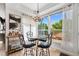 Bright dining area featuring a glass table, cushioned chairs, chandelier, bar cart, and large window with a view to the backyard at 2295 Sandhurst Dr, Castle Rock, CO 80104