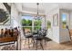 Cozy dining nook features a glass table, cushioned chairs, chandelier, bar cart, and an entrance/exit door at 2295 Sandhurst Dr, Castle Rock, CO 80104