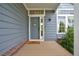 Inviting front porch with a welcoming doormat and gray front door, complemented by brick accents at 2295 Sandhurst Dr, Castle Rock, CO 80104