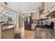 Well-appointed kitchen featuring stainless appliances, granite counters, custom cabinets, and backsplash, with a sink with exterior view at 2295 Sandhurst Dr, Castle Rock, CO 80104