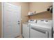 Convenient laundry room with a washer, dryer, and storage shelf at 2295 Sandhurst Dr, Castle Rock, CO 80104