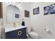 Stylish powder room features a blue vanity with gold accents and modern light fixtures at 2295 Sandhurst Dr, Castle Rock, CO 80104