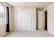Bedroom with a large window, plush carpet, and an open door to the hallway at 5840 Longs Peak St, Brighton, CO 80601