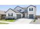 Charming two-story home showcasing a landscaped front yard and a double garage, perfect for modern living at 5840 Longs Peak St, Brighton, CO 80601
