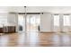 Bright open concept living area with wood floors, modern light fixture and access to the outdoor living space at 5840 Longs Peak St, Brighton, CO 80601