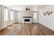 Open living room with wood floors, fireplace, and large windows offering plenty of natural light at 5840 Longs Peak St, Brighton, CO 80601