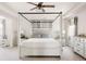 Bright main bedroom featuring a four-poster bed, neutral decor, and ample natural light at 5840 Longs Peak St, Brighton, CO 80601