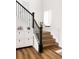 Staircase with wrought iron spindles and wooden stairs, complemented by a stylish storage cabinet at 5840 Longs Peak St, Brighton, CO 80601