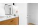 Bright bathroom with modern vanity featuring a light wood cabinet, white countertop and black framed mirror at 4362 Peach Ct, Boulder, CO 80301