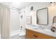 Stylish bathroom featuring shower with white tiling, and a vanity with a black framed mirror and modern lighting at 4362 Peach Ct, Boulder, CO 80301