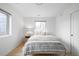 Minimalist bedroom with bright light, wood floor, and a patterned throw blanket at 4362 Peach Ct, Boulder, CO 80301