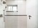 White tiled shower with a shower head and a built-in bench, and a window at 4362 Peach Ct, Boulder, CO 80301