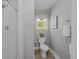 Bathroom featuring white tiled shower, toilet, and a window for natural light at 1033 Estes St, Lakewood, CO 80215