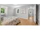 Bright bedroom featuring hardwood floors, neutral paint, and a floral patterned comforter at 1033 Estes St, Lakewood, CO 80215