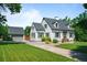 Beautiful home exterior with a detached garage and long driveway on a lush green lawn at 1033 Estes St, Lakewood, CO 80215