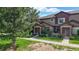 Well-kept townhome exterior with mature trees and manicured lawn at 6430 Silver Mesa Dr # D, Highlands Ranch, CO 80130