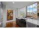 Modern kitchen boasts stainless steel appliances, black farmhouse sink, and stunning city views from large windows at 1050 Cherokee St # 403, Denver, CO 80204