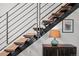 Modern staircase with wooden steps, steel railings, and adjacent cabinet with stylish lamp at 1050 Cherokee St # 403, Denver, CO 80204