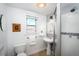 Bright bathroom featuring pedestal sink, shower stall, and updated fixtures at 1127 Clayton St, Denver, CO 80206