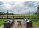 Relaxing backyard with patio seating and a fire pit overlooking an open field at 16747 E 97Th Pl, Commerce City, CO 80022