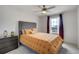 Comfortable bedroom featuring neutral tones, a ceiling fan, a window with dark curtains, and an adjacent nightstand at 16747 E 97Th Pl, Commerce City, CO 80022