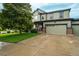 Inviting two-story home featuring a well-manicured lawn, two-car garage, and timeless exterior facade at 16747 E 97Th Pl, Commerce City, CO 80022