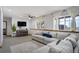 Cozy living room features a large sectional couch, modern TV, and natural light at 16747 E 97Th Pl, Commerce City, CO 80022