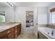 Well-appointed main bathroom featuring a dual vanity, soaking tub, and doorway to the main bedroom at 16747 E 97Th Pl, Commerce City, CO 80022