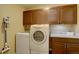 Functional laundry room with washer, dryer, cabinets, and countertop at 5604 E Nichols Pl, Centennial, CO 80112