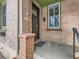 Brick front porch with a dark brown door and sidelight window at 3256 N Clay St, Denver, CO 80211