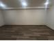 Unfinished basement space with wood-look flooring and ample room at 9983 Cottoncreek Dr, Highlands Ranch, CO 80130