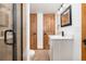 Bathroom boasts a sleek vanity, shower, and dual wooden doors, with modern fixtures at 9983 Cottoncreek Dr, Highlands Ranch, CO 80130