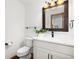 Bright bathroom features a white vanity with a modern faucet and a decorative framed mirror at 9983 Cottoncreek Dr, Highlands Ranch, CO 80130