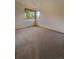 Empty bedroom with carpet floors and a window overlooking a wooded area at 9983 Cottoncreek Dr, Highlands Ranch, CO 80130