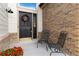 Charming front porch with brick accents, seating area, and welcoming front door with wreath at 9983 Cottoncreek Dr, Highlands Ranch, CO 80130