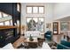 Bright living room featuring large windows, tall ceilings, fireplace, and hardwood floors at 9983 Cottoncreek Dr, Highlands Ranch, CO 80130