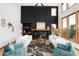 Bright living room with a black paneled fireplace, large windows, and hardwood floors at 9983 Cottoncreek Dr, Highlands Ranch, CO 80130