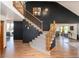 Inviting foyer with hardwood floors, curved staircase, and dark accent wall creates a striking entrance at 9983 Cottoncreek Dr, Highlands Ranch, CO 80130