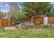 Serene backyard featuring a decorative bridge, lush landscaping, and a wooden fence at 6062 S Emporia Cir, Englewood, CO 80111