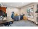 Comfortable bedroom with a large window, work desk, and view to the outside deck stairs at 6062 S Emporia Cir, Englewood, CO 80111
