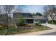Home exterior showcasing the landscaped front yard with flower beds, and trees at 6062 S Emporia Cir, Englewood, CO 80111
