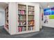 Hallway featuring custom built-in bookshelves stocked with reading material and wall art at 6062 S Emporia Cir, Englewood, CO 80111